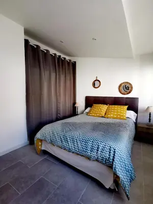 a bedroom with a bed with yellow pillows at Indè Noi - Maison de village proche commodités in Murato