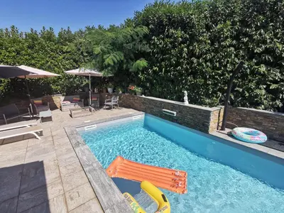 a swimming pool with a chair and a swimming pool at Indè Noi - Maison de village proche commodités in Murato