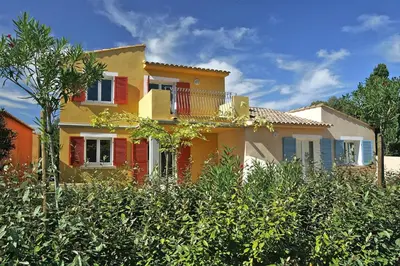 a yellow house with red shutters and trees at Lovely apartment in Borgo with shared pool in Borgo