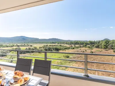a breakfast table with a view of the mountains at Apartment Stanatura-5 by Interhome in Porto-Vecchio