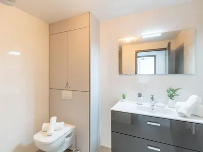 a bathroom with a toilet and a sink and a mirror at Apartment Stanatura-5 by Interhome in Porto-Vecchio