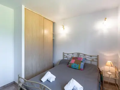 a small bedroom with a bed with towels on it at Villa Les Rosiers by Interhome in Porto-Vecchio