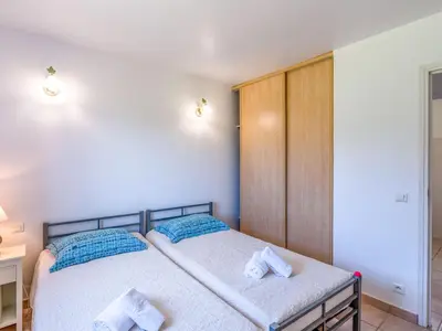a bedroom with two beds with blue pillows at Villa Les Rosiers by Interhome in Porto-Vecchio