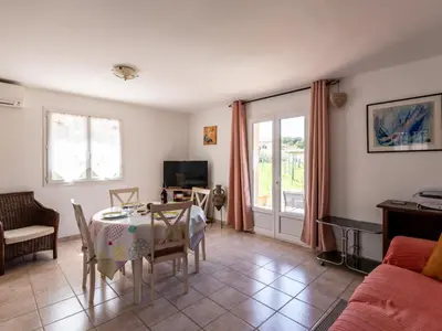a living room with a table and a couch at Villa Les Rosiers by Interhome in Porto-Vecchio
