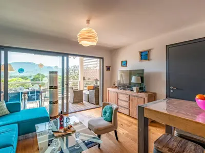 a living room with a blue couch and a glass table at Apartment Résidence Cita Di Sali 12 by Interhome in Porto-Vecchio