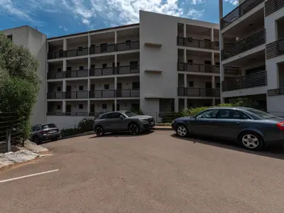 two cars parked in front of a building at Apartment Résidence Cita Di Sali 12 by Interhome in Porto-Vecchio