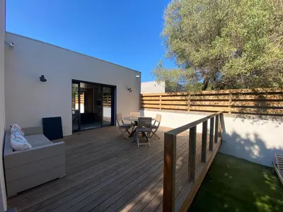 a wooden deck with a table and chairs on it at Mini-Villa Jade in Bonifacio