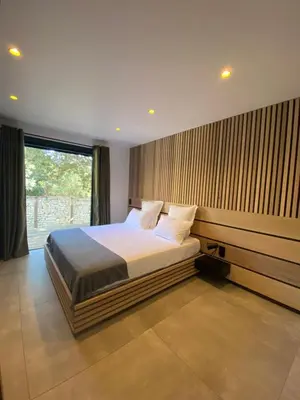 a bedroom with a bed and a large window at Mini-Villa Jade in Bonifacio