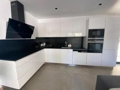 a white kitchen with black and white cabinets at Mini-Villa Jade in Bonifacio