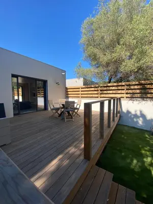 a wooden deck with a table and chairs on it at Mini-Villa Jade in Bonifacio