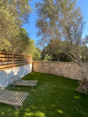 a garden with a bench and a brick wall at Mini-Villa Jade in Bonifacio