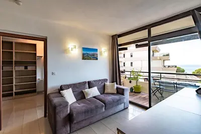a living room with a couch and a balcony at Le Balcon dAjaccio in Ajaccio