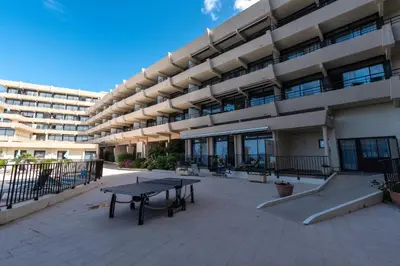 a large building with a ping pong table in the courtyard at Le Balcon dAjaccio in Ajaccio