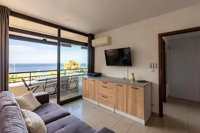 a living room with a couch and a view of the ocean at Le Balcon dAjaccio in Ajaccio