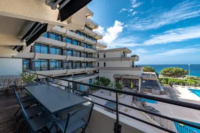 a balcony with a table and chairs and the ocean at Le Balcon dAjaccio in Ajaccio