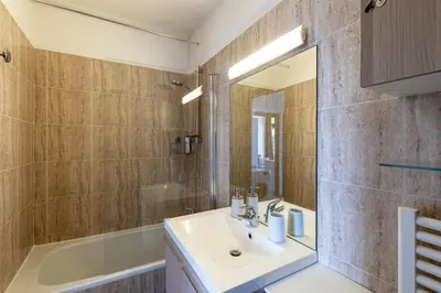a bathroom with a sink and a mirror and a tub at Le Balcon dAjaccio in Ajaccio