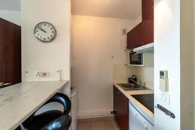 a kitchen with a counter and a clock on the wall at Le Balcon dAjaccio in Ajaccio
