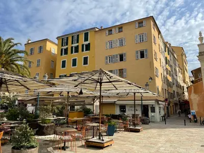 a patio with tables and umbrellas in front of a building at Ajaccio : appartement centre historique in Ajaccio