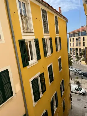 a yellow building with green shutters on it at Ajaccio : appartement centre historique in Ajaccio