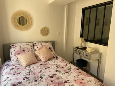 a bedroom with a bed and a mirror and a table at Ajaccio : appartement centre historique in Ajaccio