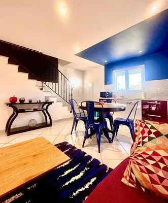 a living room with a table and chairs and a staircase at Campo Vecchio Dracena et Piscine in Ghisonaccia
