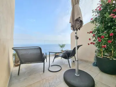 a patio with a television and a chair and an umbrella at Mare è rocca in Bonifacio