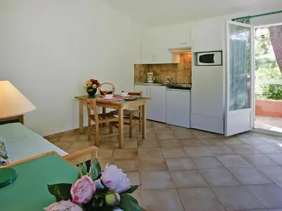 a swimming pool with a person sitting on the side of it at Apartment in Corsica with Beach Access in Borgo