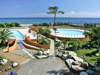 a house in the middle of a yard with trees at Apartment in Corsica with Beach Access in Borgo