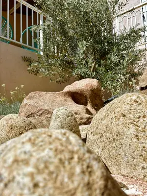 a pile of rocks in front of a building at Campo Vecchio Kamerops et piscine in Ghisonaccia