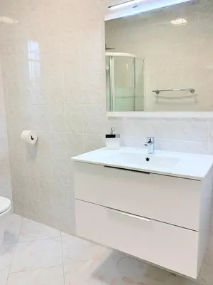a white bathroom with a sink and a mirror at Campo Vecchio Kamerops et piscine in Ghisonaccia