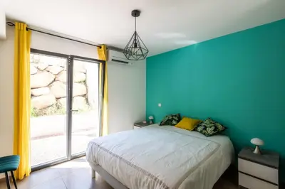 a bedroom with a bed and a large window at L'Aurore de Cruciata - Appt vue baie d'Ajaccio in Pietrosella