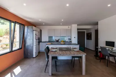 a kitchen and dining room with a table and chairs at L'Aurore de Cruciata - Appt vue baie d'Ajaccio in Pietrosella