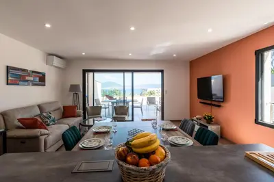 a living room with a table with fruit on it at L'Aurore de Cruciata - Appt vue baie d'Ajaccio in Pietrosella