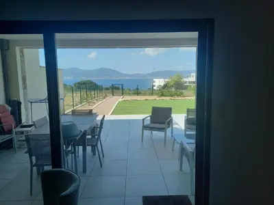 a view of a dining room with a table and chairs at L'Aurore de Cruciata - Appt vue baie d'Ajaccio in Pietrosella