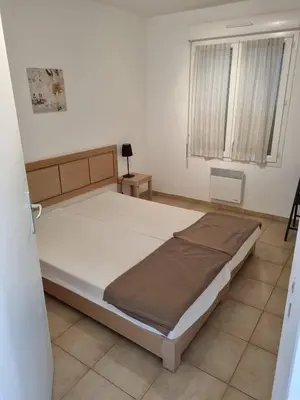 a bedroom with a bed and a window at Appartement T2 dans résidence avec piscine in Moriani Plage