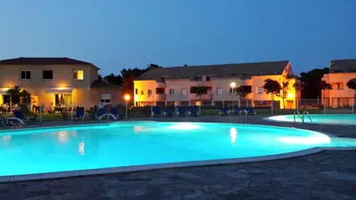 a large blue swimming pool in front of some buildings at Appartement T2 dans résidence avec piscine in Moriani Plage