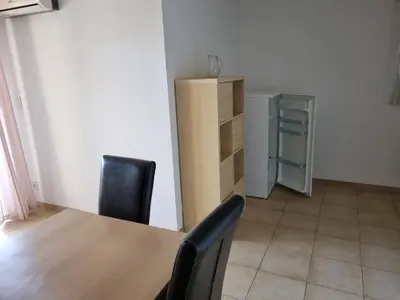 a dining room with a table and chairs and a cabinet at Appartement T2 dans résidence avec piscine in Moriani Plage