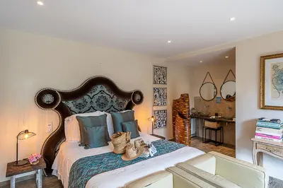 a bedroom with a large bed with a table at Casa del Sole Chambres d'Hotes de Charme in Favone