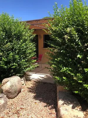 a house with two trees in front of a yard at Pleasant private villa Located in a garden of 8000m2 with trees in Porto-Vecchio