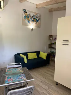 a living room with a couch and a table at Pleasant private villa Located in a garden of 8000m2 with trees in Porto-Vecchio