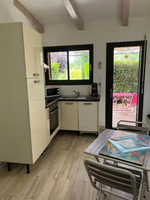 a kitchen with a table and chairs in a room at Pleasant private villa Located in a garden of 8000m2 with trees in Porto-Vecchio