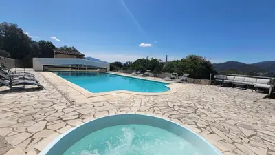 a swimming pool with a stone patio and a house at DOMAINE CARDU in Cardo-Torgia
