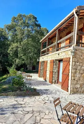a stone building with two benches in front of it at DOMAINE CARDU in Cardo-Torgia