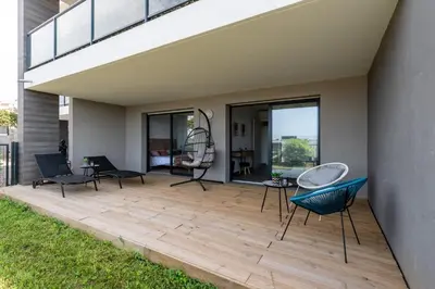 a patio with chairs and tables and glass doors at L'étincelle de Stagnola - Vue mer in Pietrosella