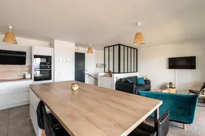 a kitchen and living room with a wooden table at L'étincelle de Stagnola - Vue mer in Pietrosella