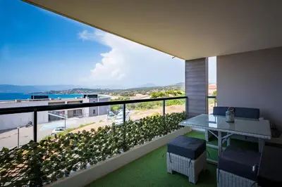 a room with a balcony with a table and chairs at L'étincelle de Stagnola - Vue mer in Pietrosella
