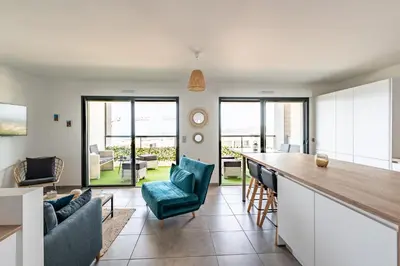 a kitchen and living room with a bar and chairs at L'étincelle de Stagnola - Vue mer in Pietrosella