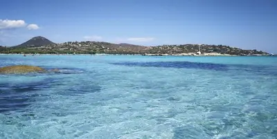 a large body of water with an island in the background at Les Jardins De Santa Giulia - Charmante chambre dhte 1 in Porto-Vecchio