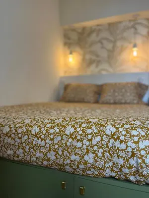 a bed with a floral bedspread on top of it at studio d'architecte superieur - centre ville historique in Ajaccio