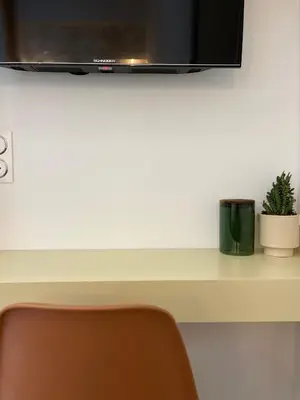 a white counter with a tv and a chair at studio d'architecte superieur - centre ville historique in Ajaccio